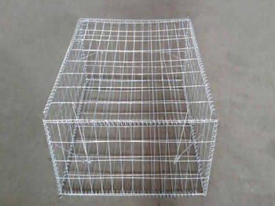 A galvanized welded gabion on the ground.